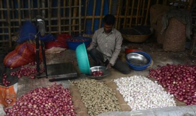 Vânzător de legume (ceapă, usturoi și ghimbir) în India. Sursa foto: Profimedia Images
