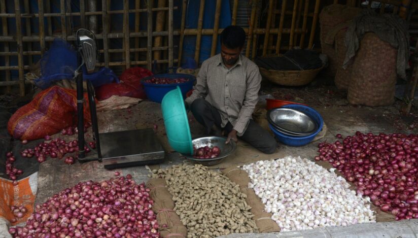 Vânzător de legume (ceapă, usturoi și ghimbir) în India. Sursa foto: Profimedia Images