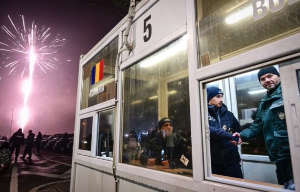 Un polițist de frontieră român și unul bulgar își dau mâinile la punctul de trecere Gurgiu-Ruse. Sursa foto: Profimedia Images